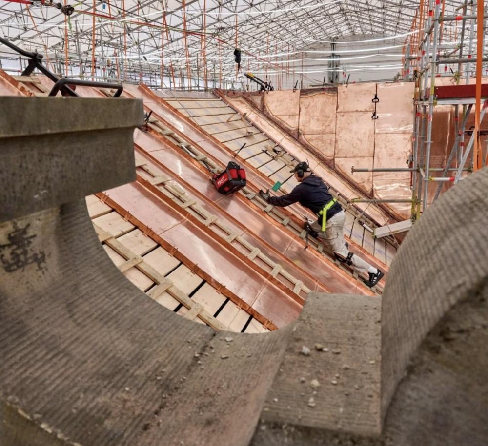 Des travailleurs en construction effectuent des travaux sur le toit d'un immeuble