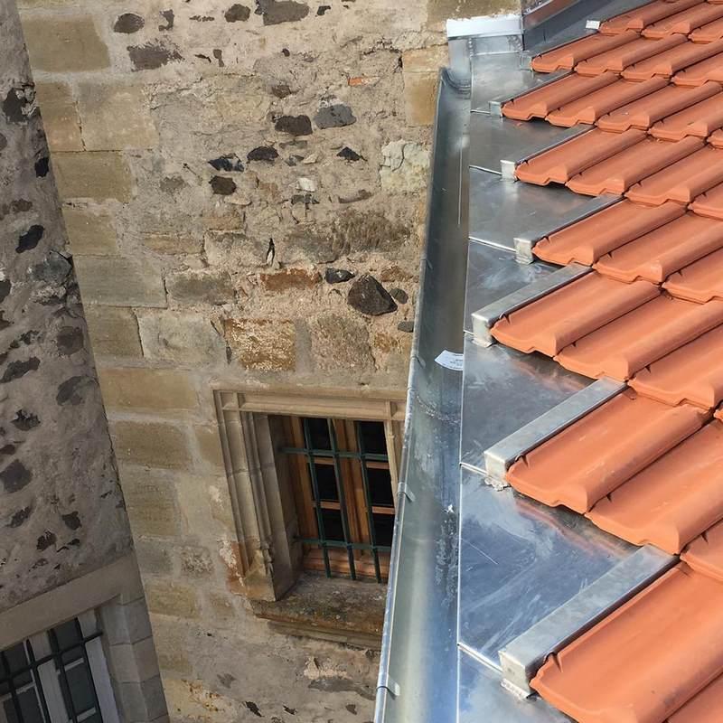 Vue rapprochée d'une fenêtre, toit au-dessus et gouttière en métal